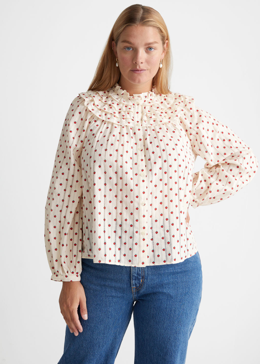 model in button down white blouse with red strawberry print