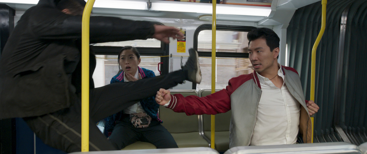 Shang-Chi fighting off attackers in a moving bus as Katy looks on