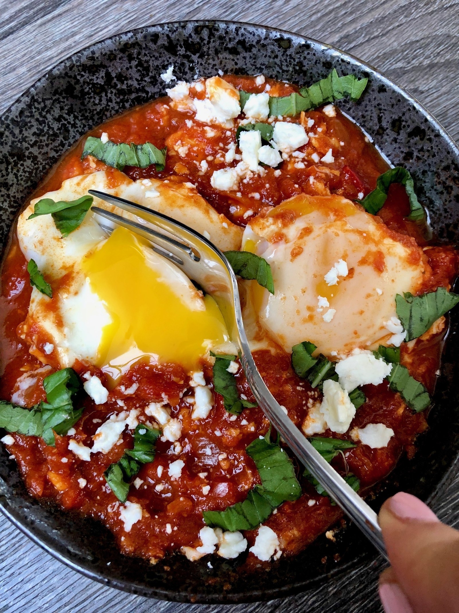 Eggs baked in tomato sauce with basil and feta