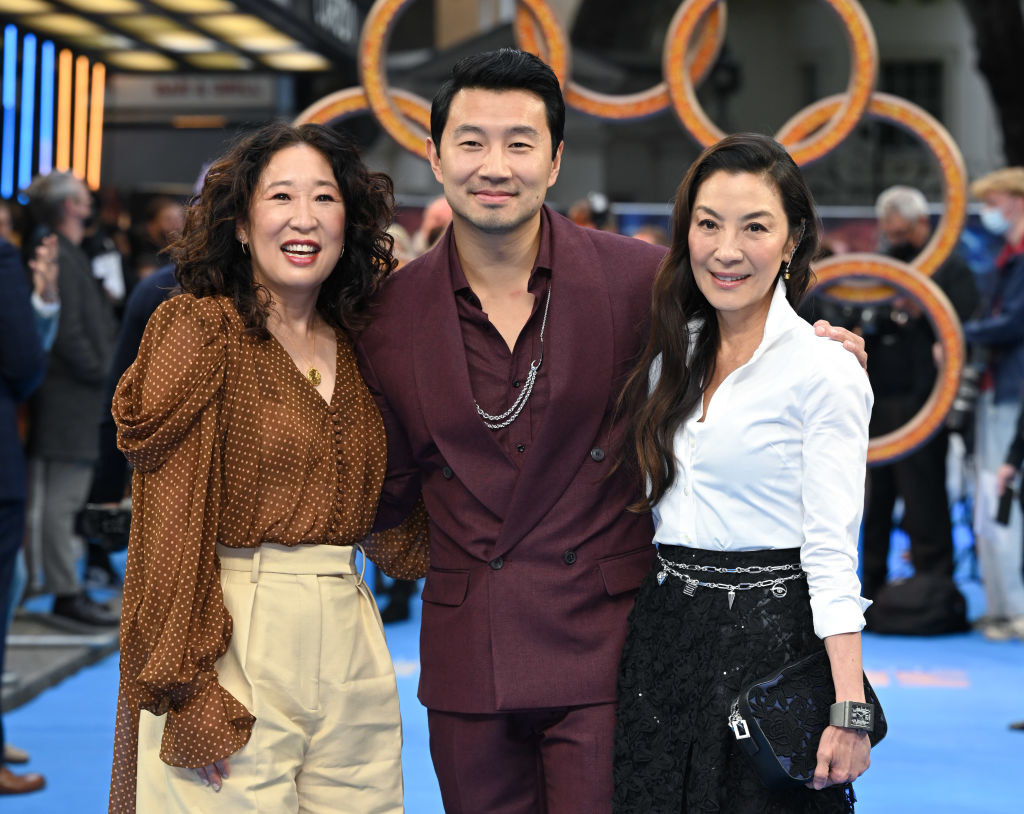 Simu at the premiere of the film posing for a photo with Michelle Yeoh and Sandra Oh