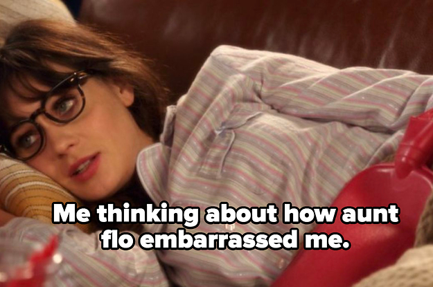 Jessica from New Girl is pictured laying on the couch with a heated water bottle on her belly.