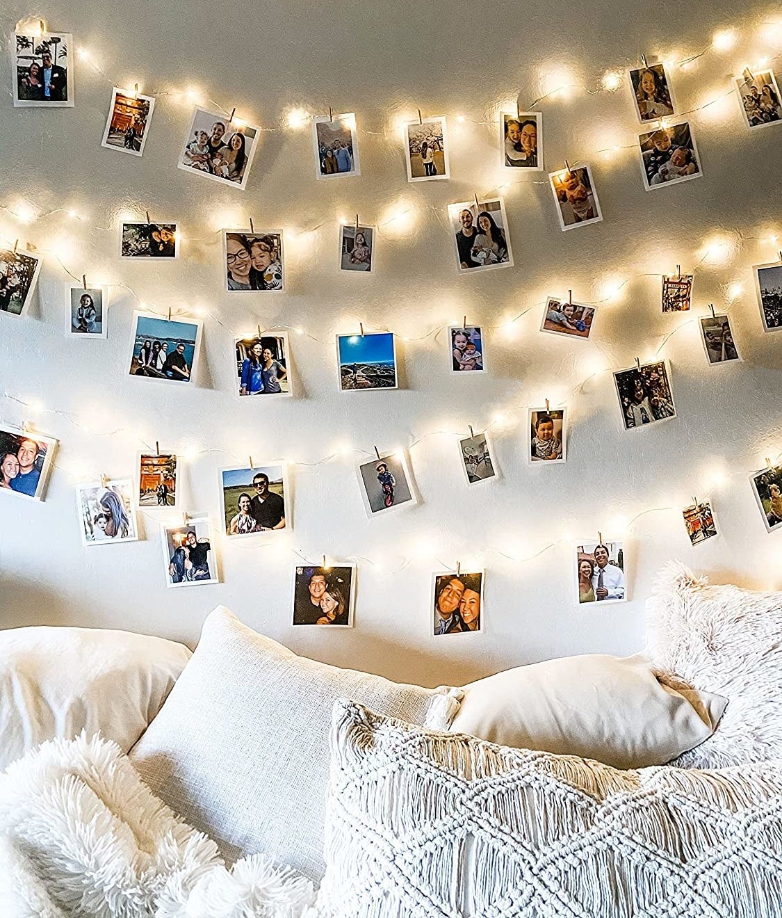 The lights hanging on a wall and strung with photos on clothespins
