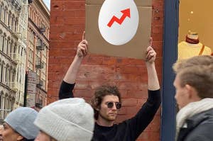模因带着一个拿着标志的家伙，标有一个带有BuzzFeed徽标的鸡蛋。yabo sports
