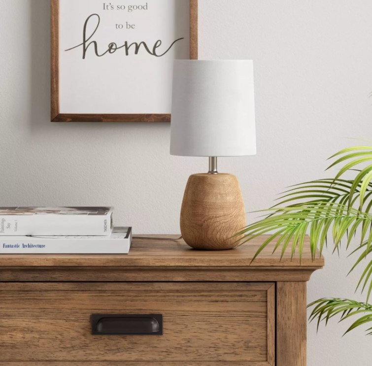 An image of a wood accent lamp on a bedroom dresser