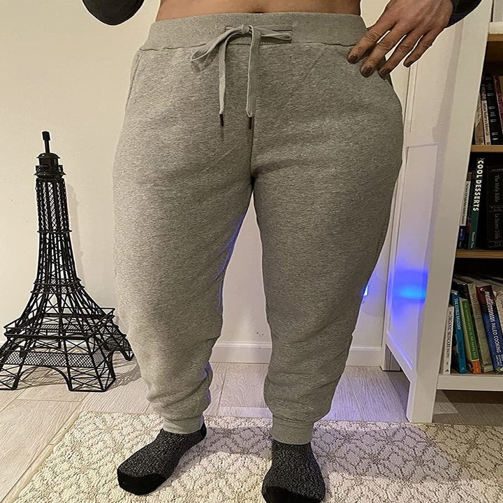 a reviewer wearing the light gray sweatpants