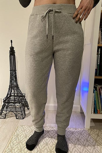 a reviewer wearing the light gray sweatpants