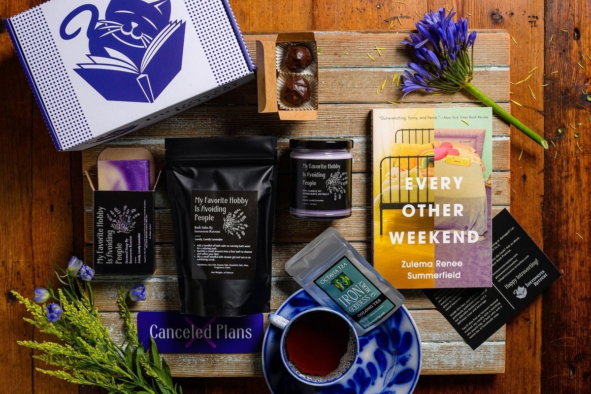A novel with the words &quot;Every Other Weekend&quot; and an assortment of bath products with a purple box