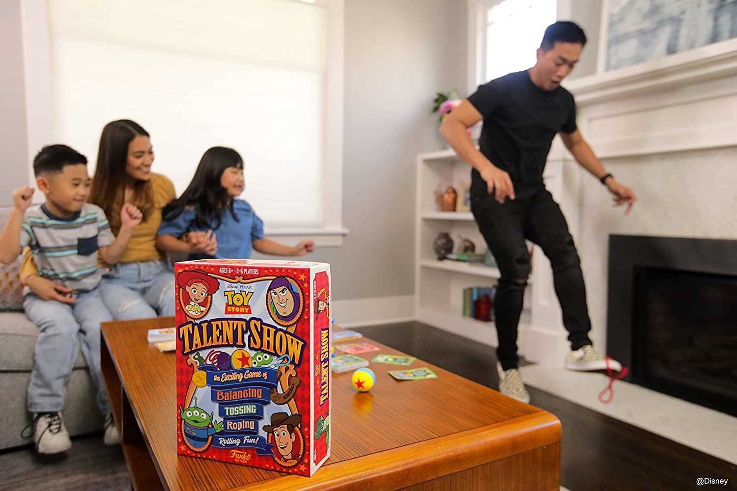 a family playing the game with a parent balancing something on their foot
