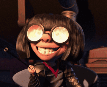 Edna Mode with a burning fire reflected in her glasses as she smiles maniacally