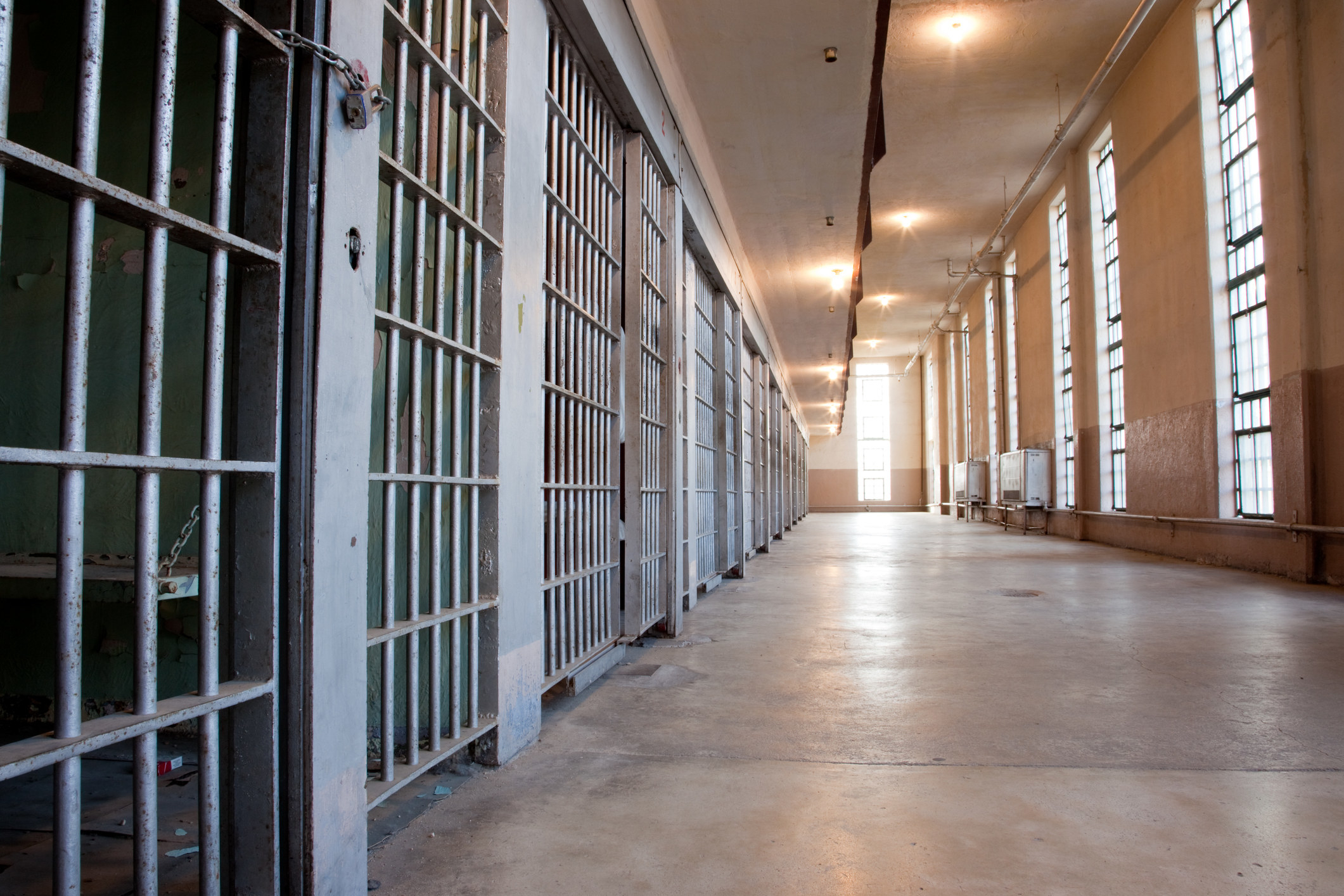 Jail cells on the left in the hallway of a state prison