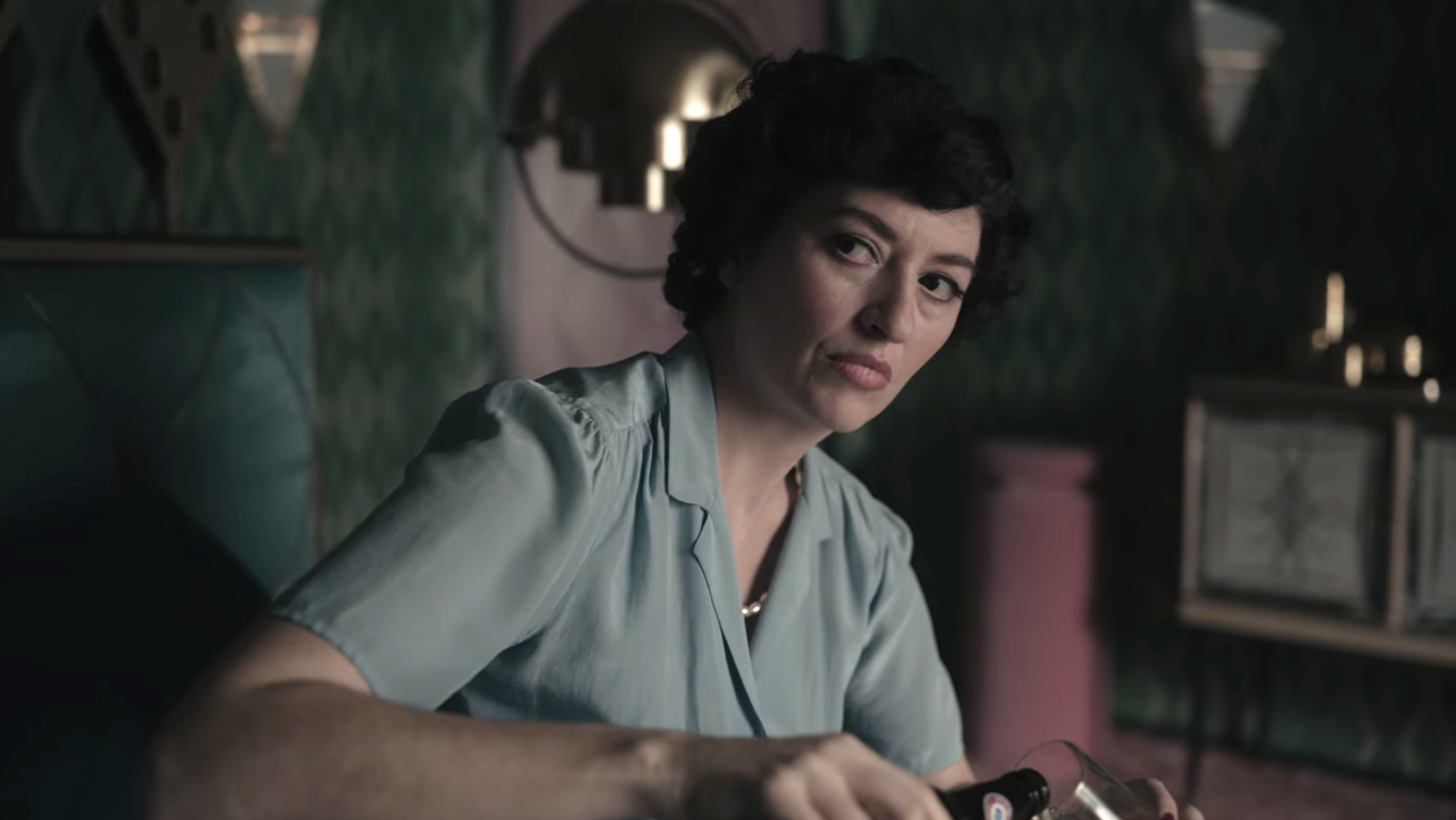 Marielle Heller as Alma Wheatley pours herself a drink in front of her daughter in &quot;The Queen&#x27;s Gambit&quot;