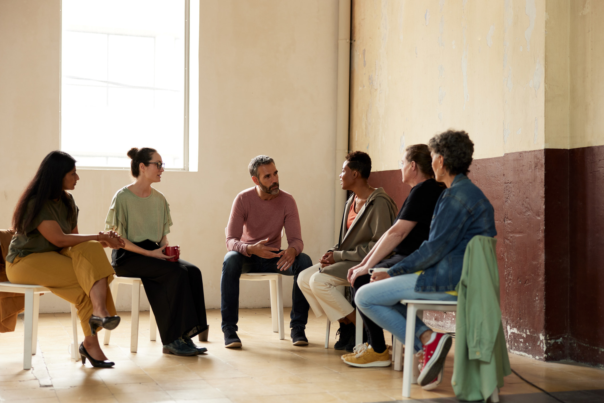 Alcoholics Anonymous participants in discussion while in chairs in a circle