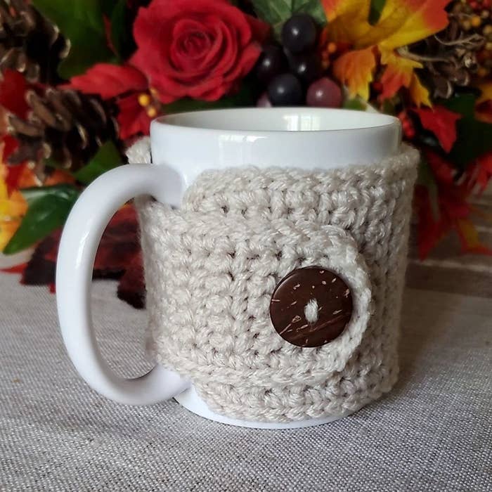 A mug with the buttoned coozie-style sweater