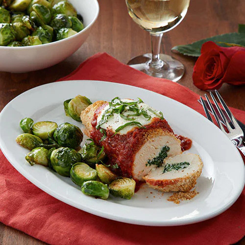 mozzarella and spinach stuffed chicken topped with marinara sauce and served with Brussels sprouts