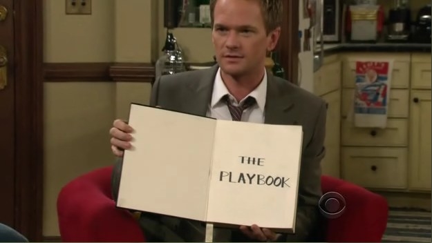 barney holds up a notebook with the words &quot;the playbook&quot; written on the first page
