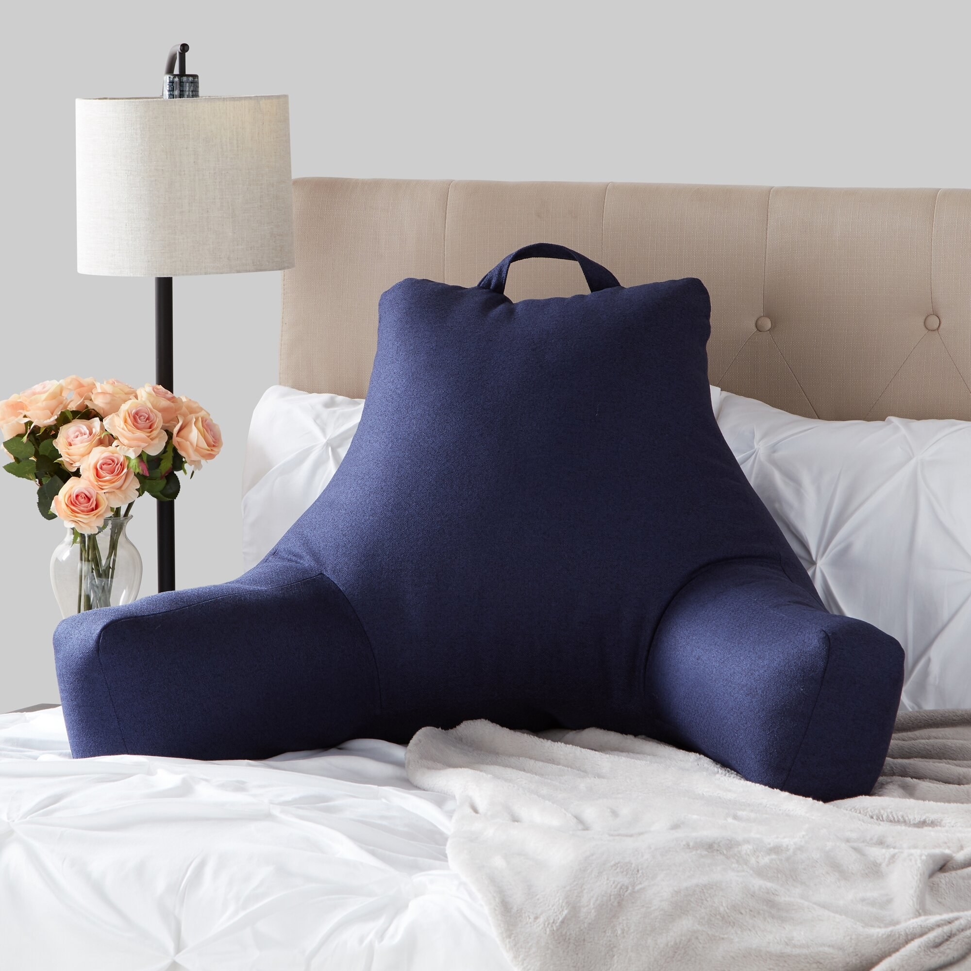 The dark blue backrest pillow on a bed