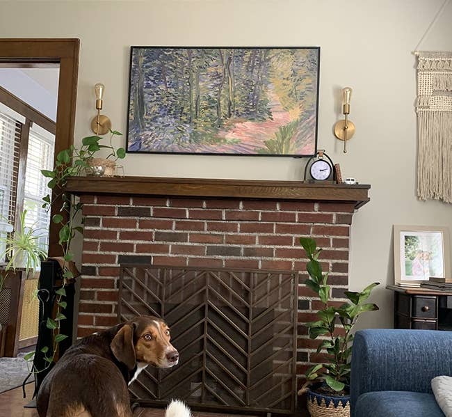 a reviewer shows the frame TV above their fire place