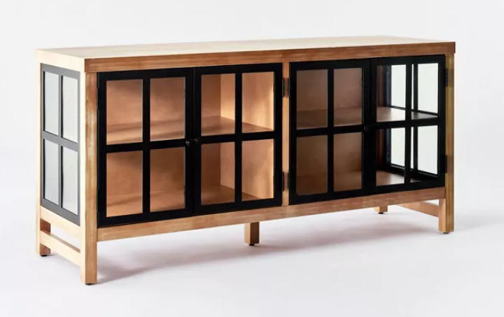 A light-brown wooden and black metal TV stand with glass double-doors that open up towards you and internal storage shelves.