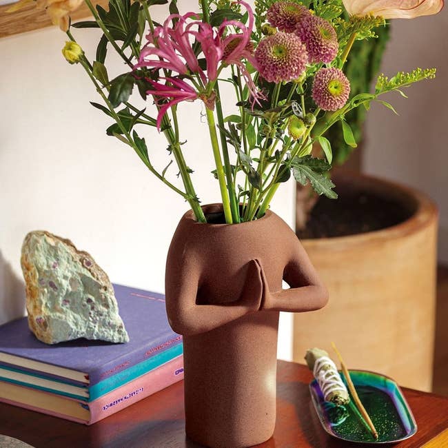 Vase on table inside of home with flowers inside of it