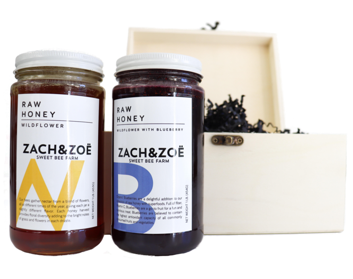 Two jars of honey next to a gift box