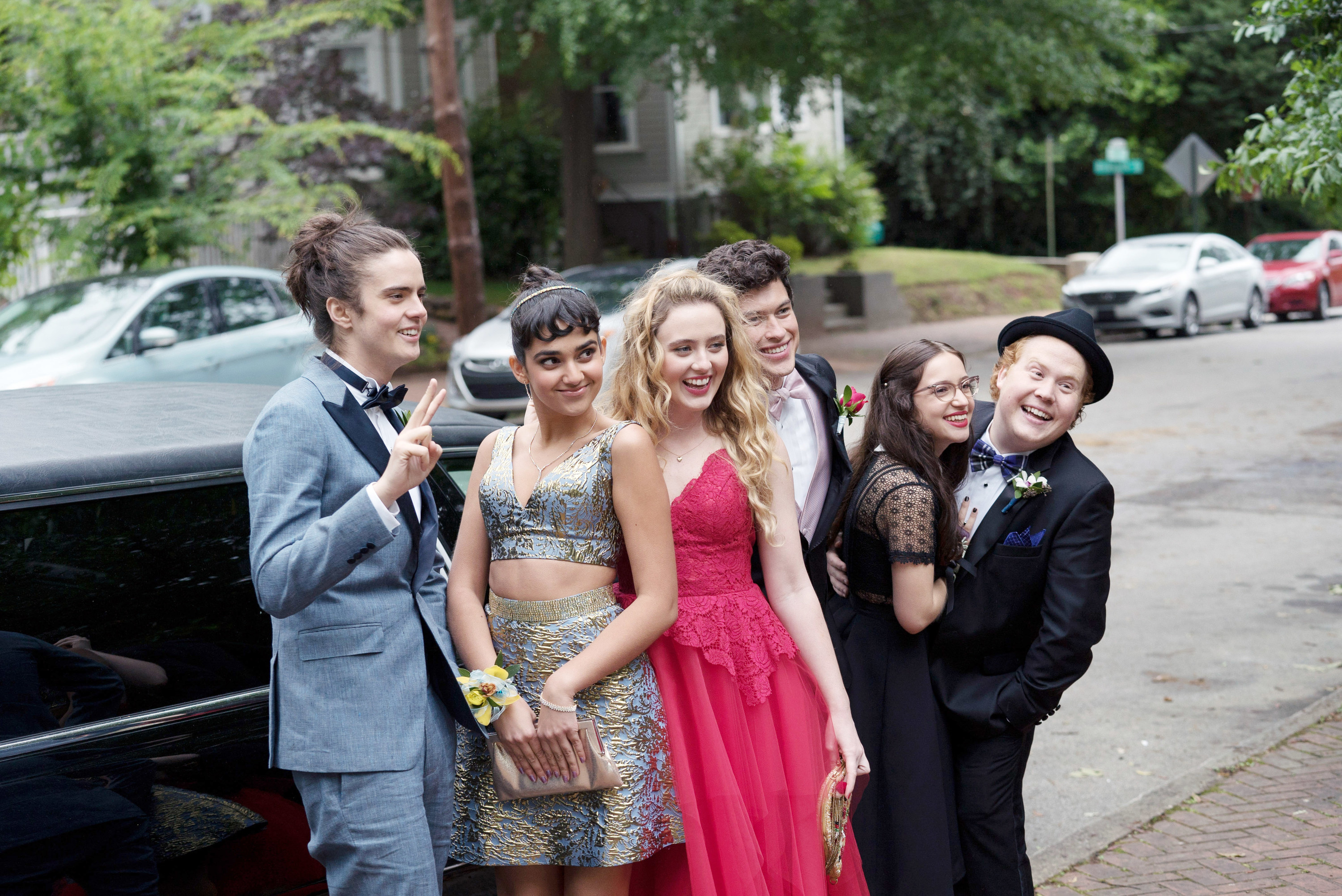 the teens posing in front of their prom limo