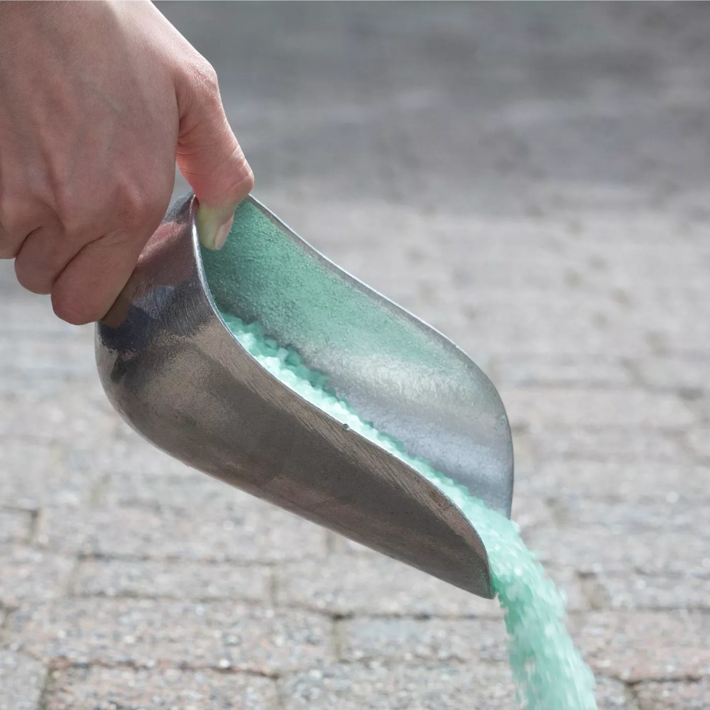 The ice melt being poured onto a driveway