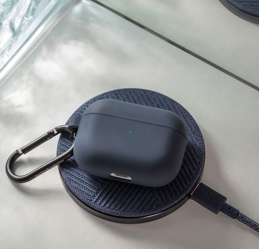 a pair of airpods charging on the circular wireless charger
