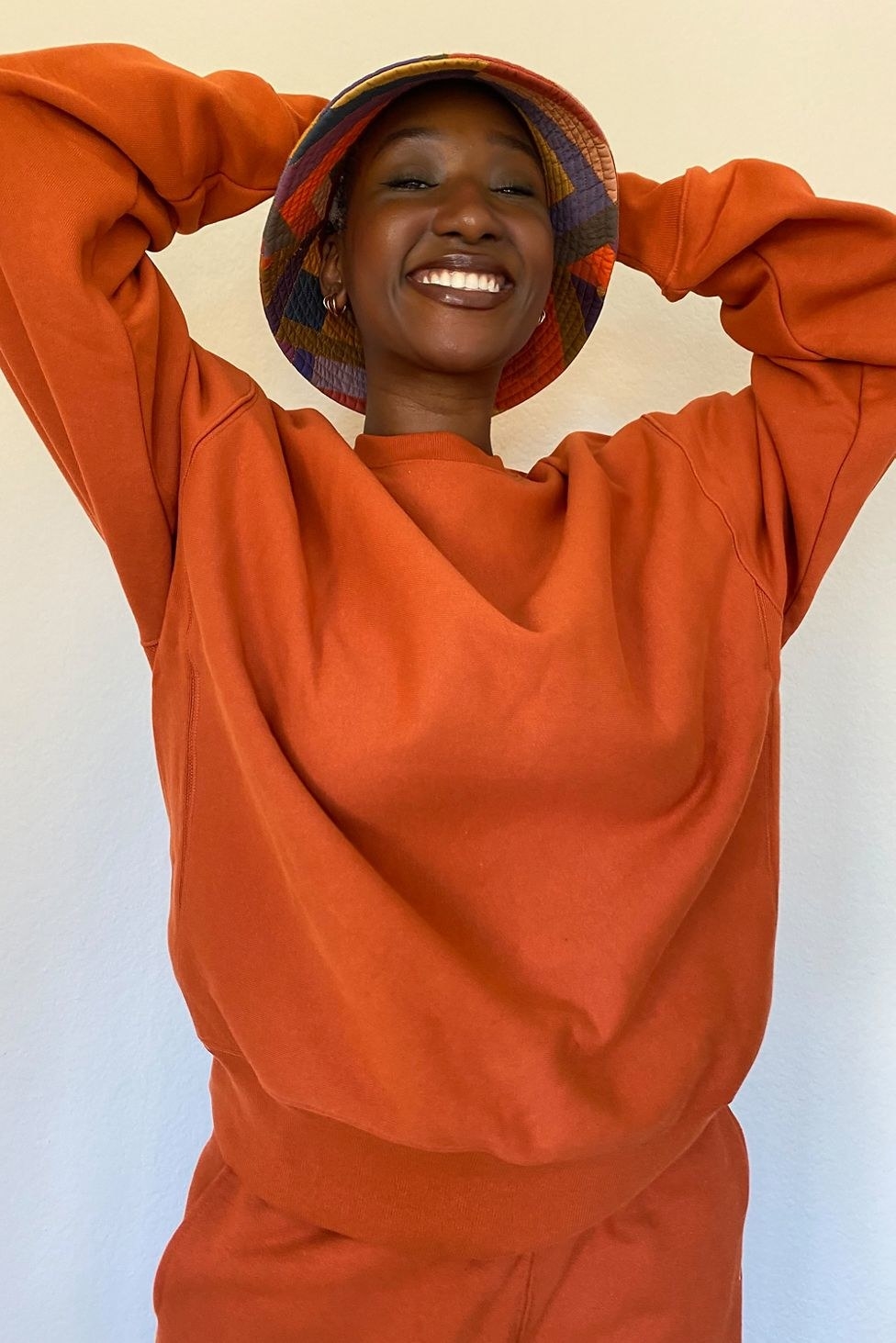 model in orange crewneck sweatshirt