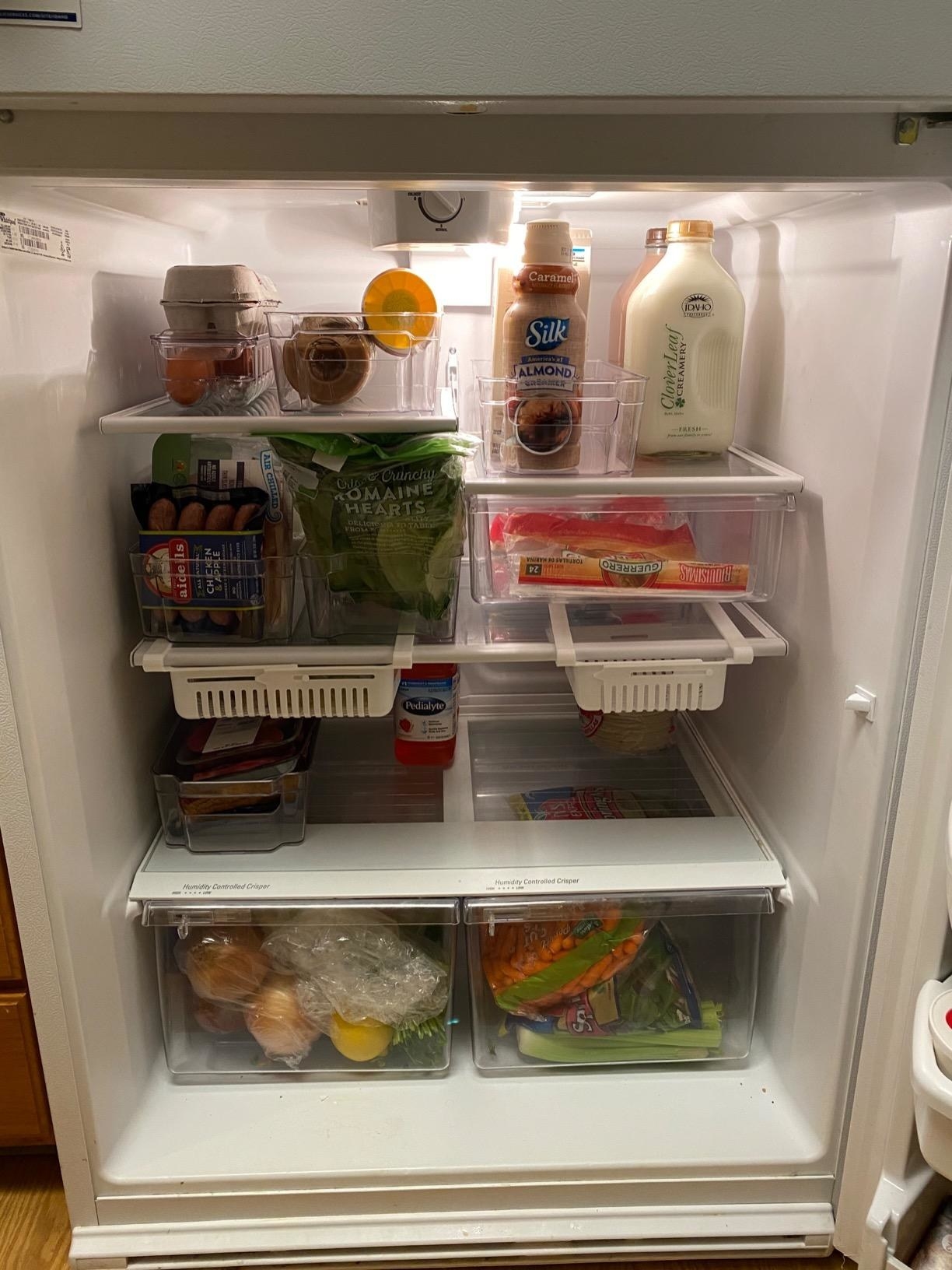 reviewer&#x27;s fridge organized using grocery organizers