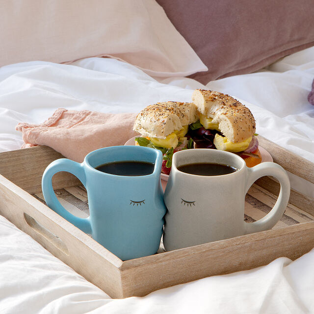 Blue and gray kissing mugs on a breakfast tray