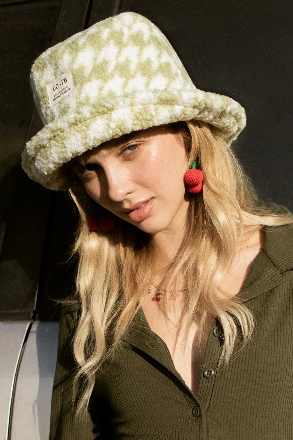 model in a white and green checkered sherpa bucket hat