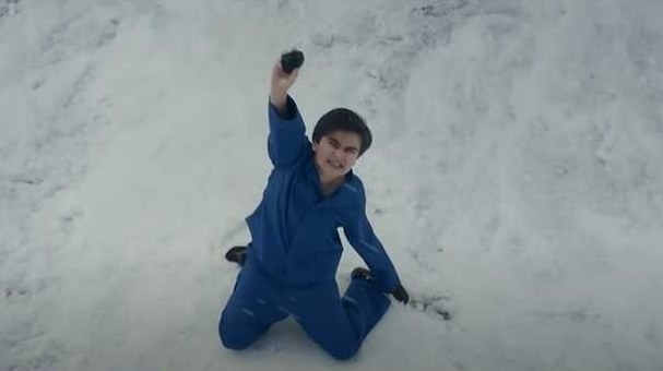 Kid cries in the snow holding up coal