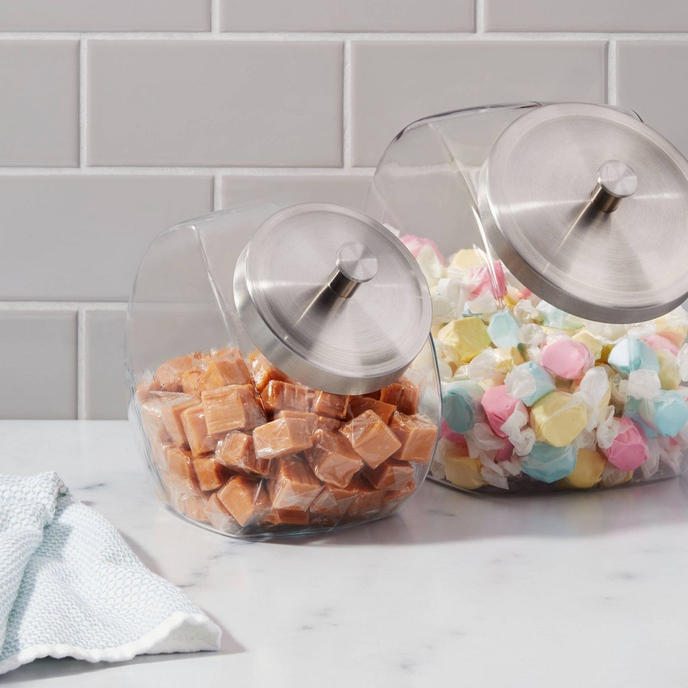 the two jars on a counter, both filled with candy