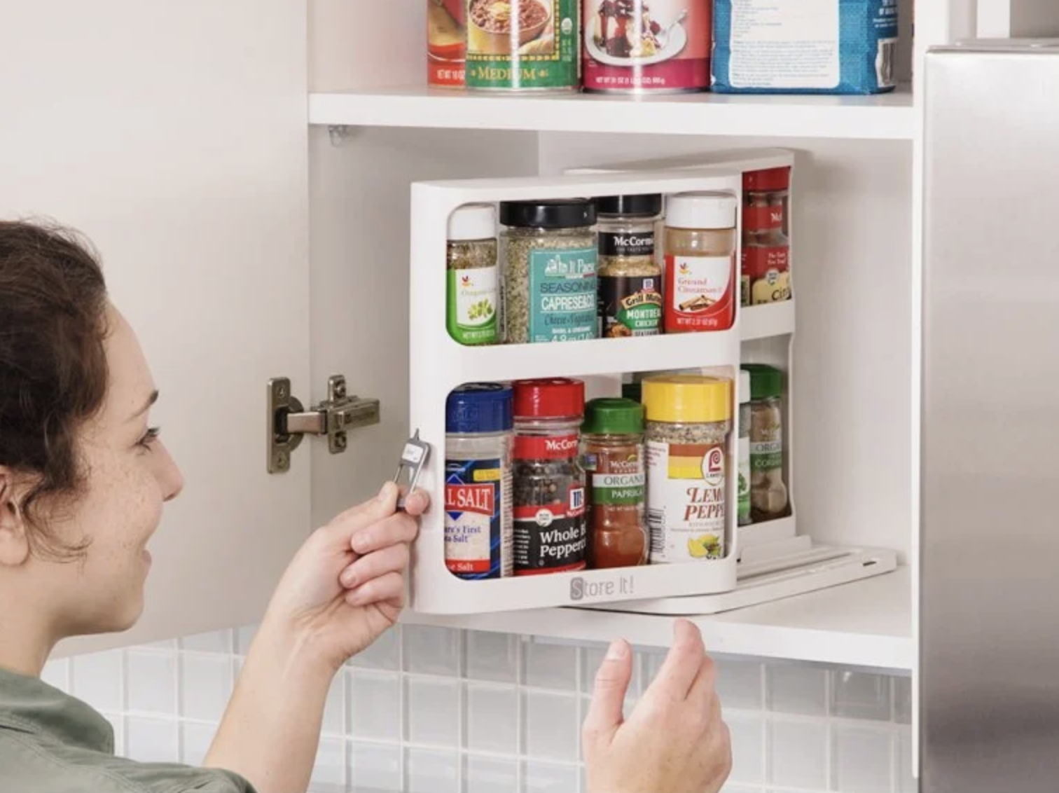 a model pulling on the cabinet organizer to reach spices