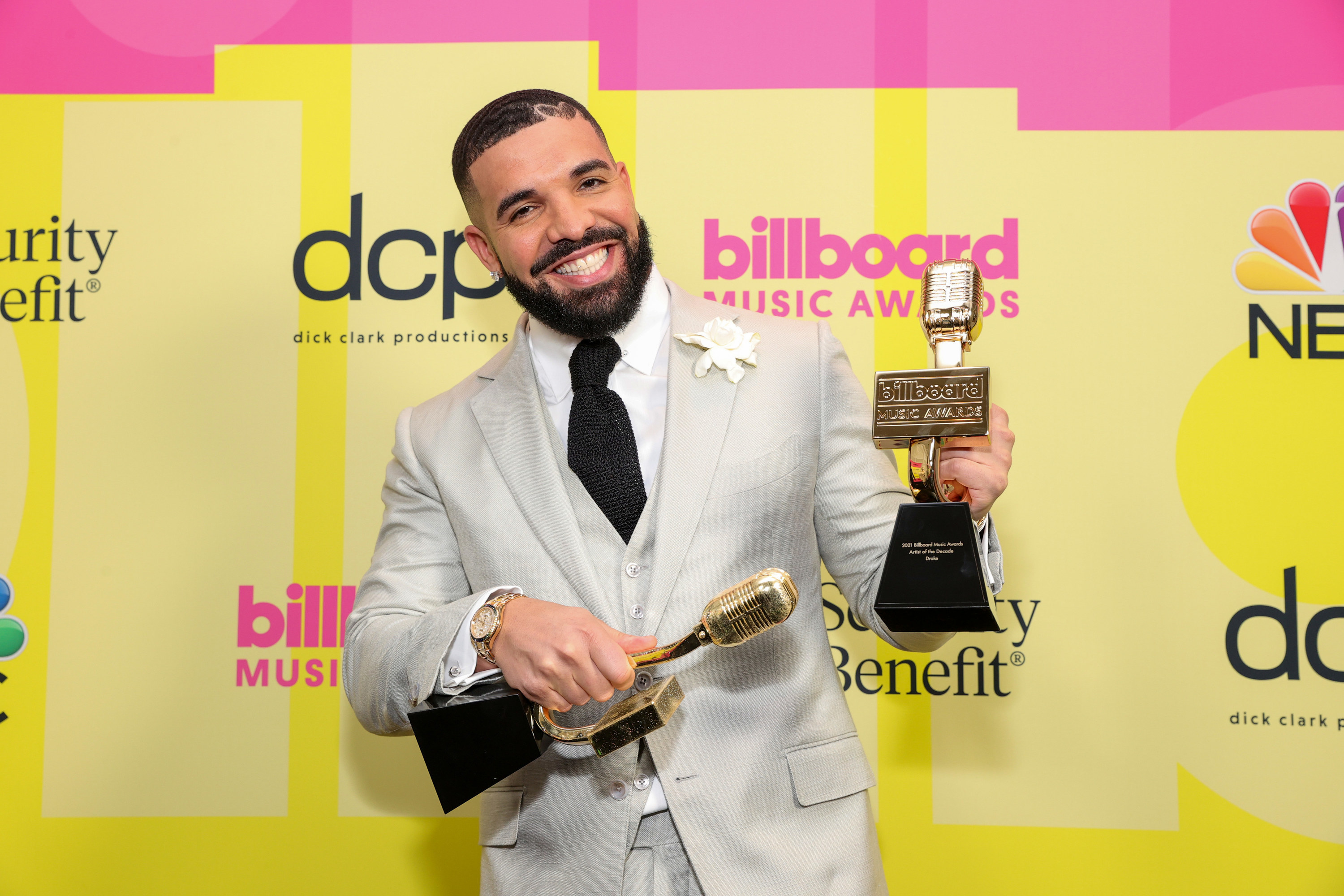 Drake smiles as he holds his two BillBoard music awards