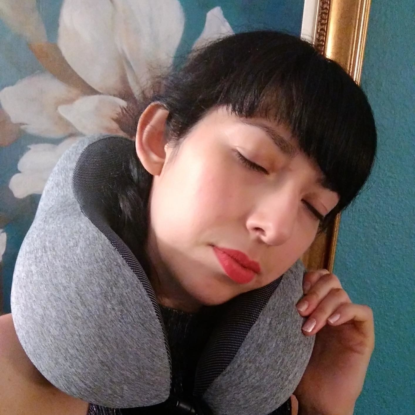 Reviewer pretending to sleep with the pillow around their neck