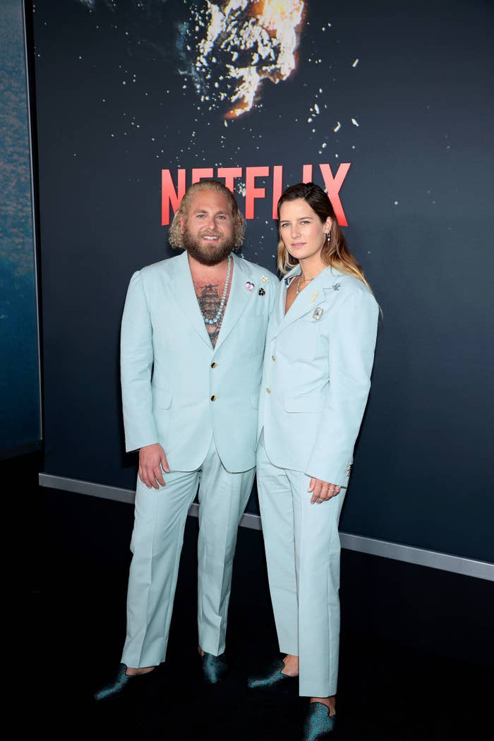 The couple is also wearing identical satin blue smoking slippers