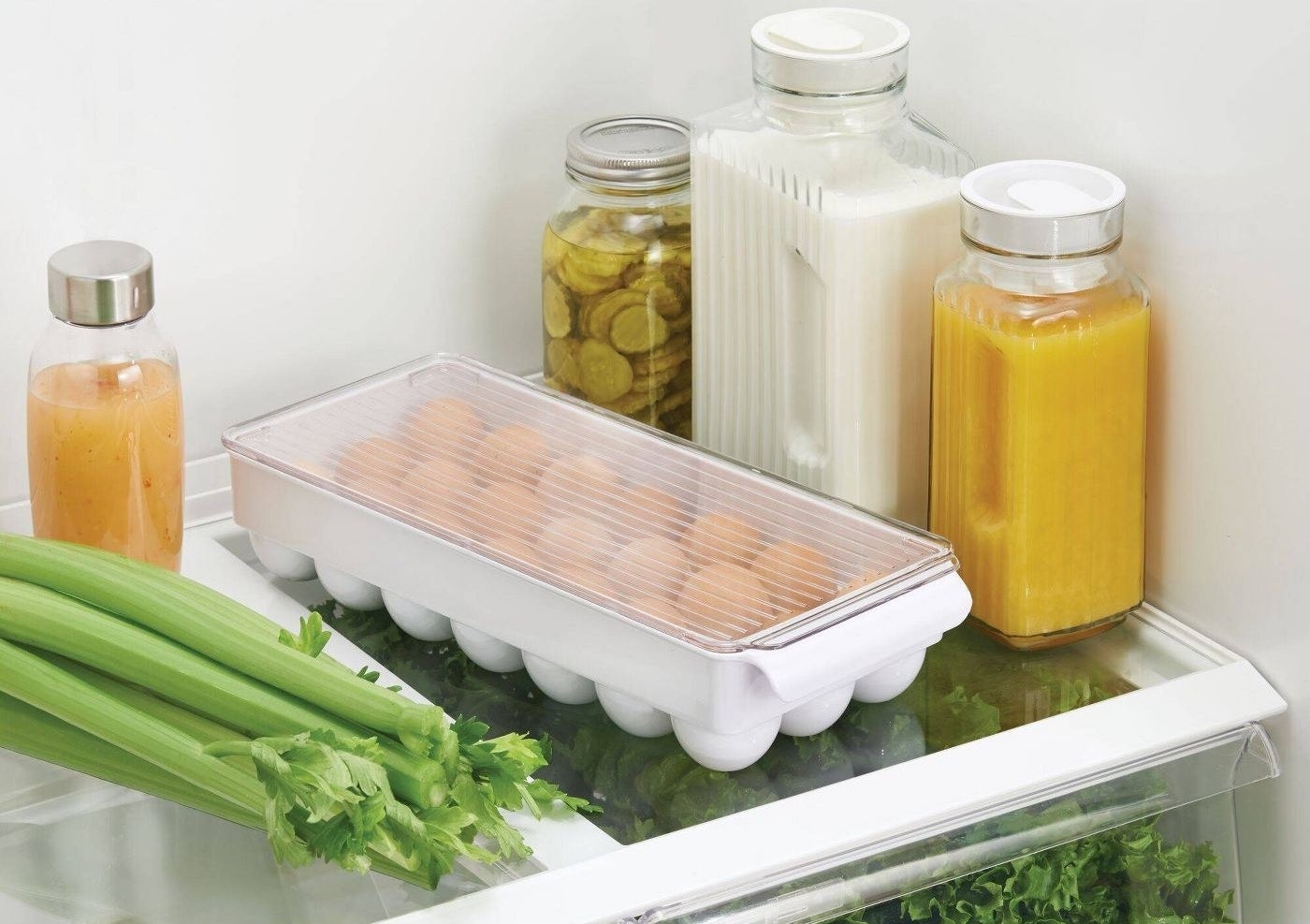 the egg container in a fridge with various other groceries