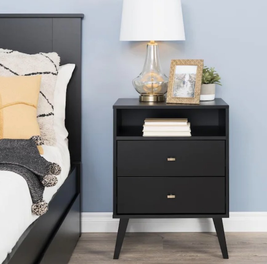 A black nightstand with two drawers and two shelves