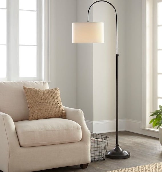 floor lamp with a curved adjustable base and a round shade