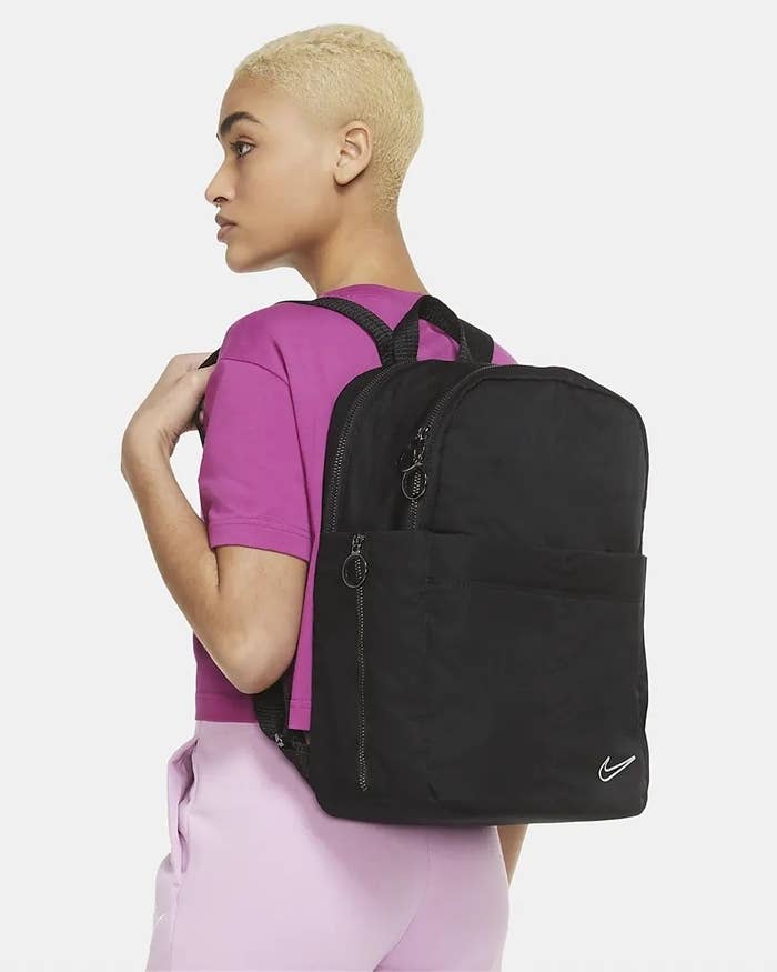 Model using black backpack in pink outfit