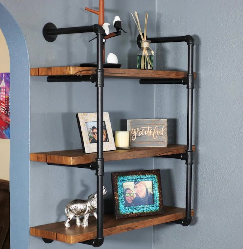 A 3-tier, brown wood/black metal floating bookcase