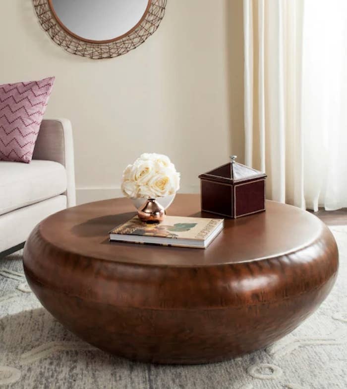 A copper metal round drum coffee table