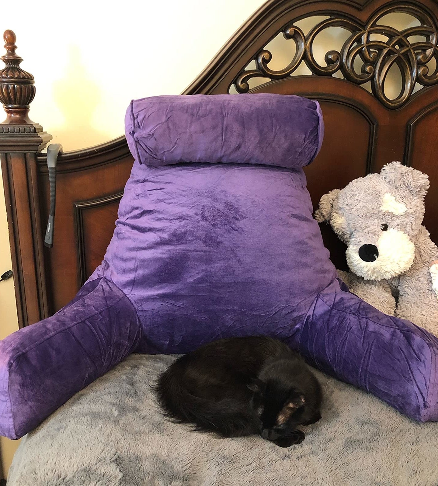 reviewer image of purple backrest pillow on a bed