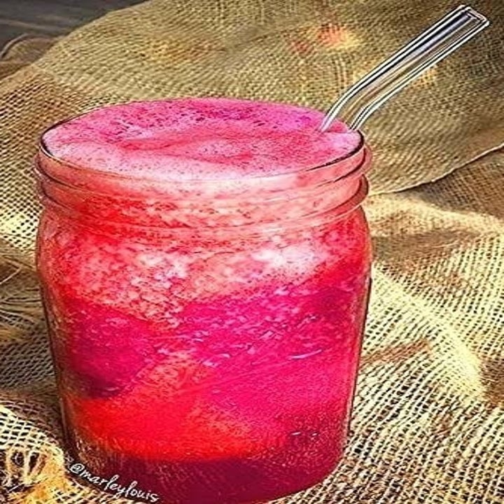 a pink drink with a bent glass straw in it
