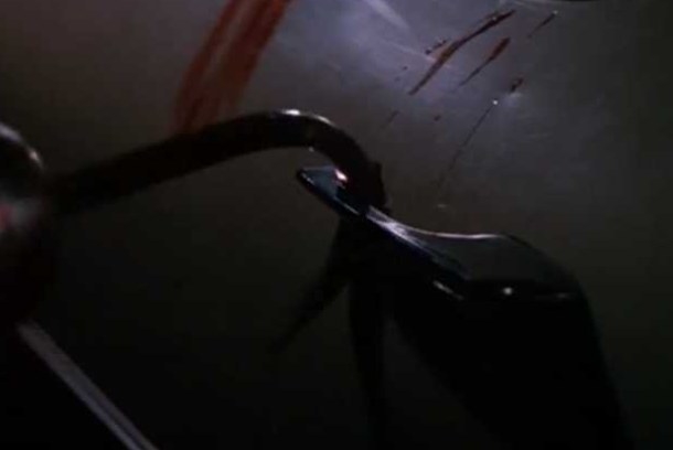 A hook pulls a bloodied door handle