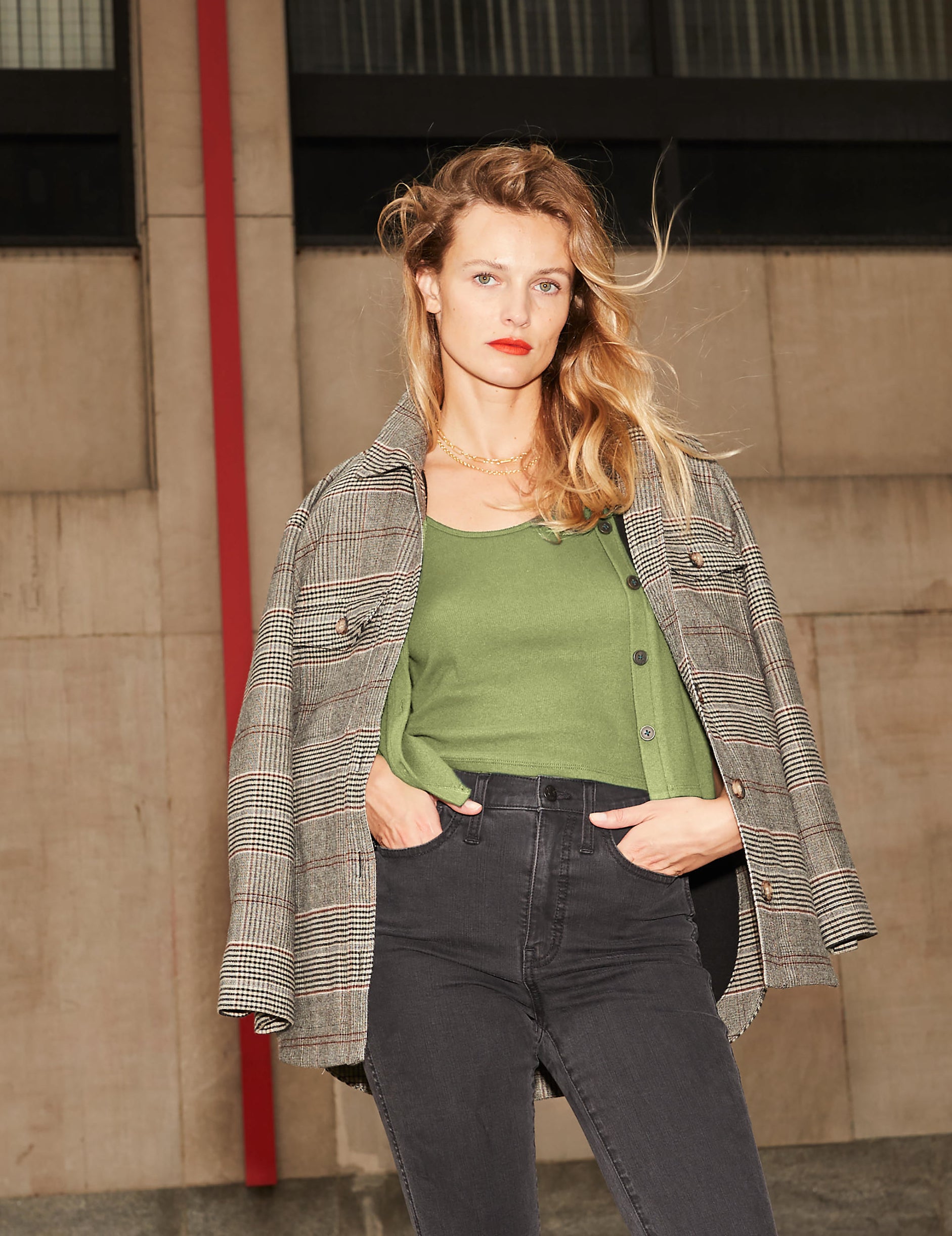 model wearing the brown, beige, and red plaid jacket