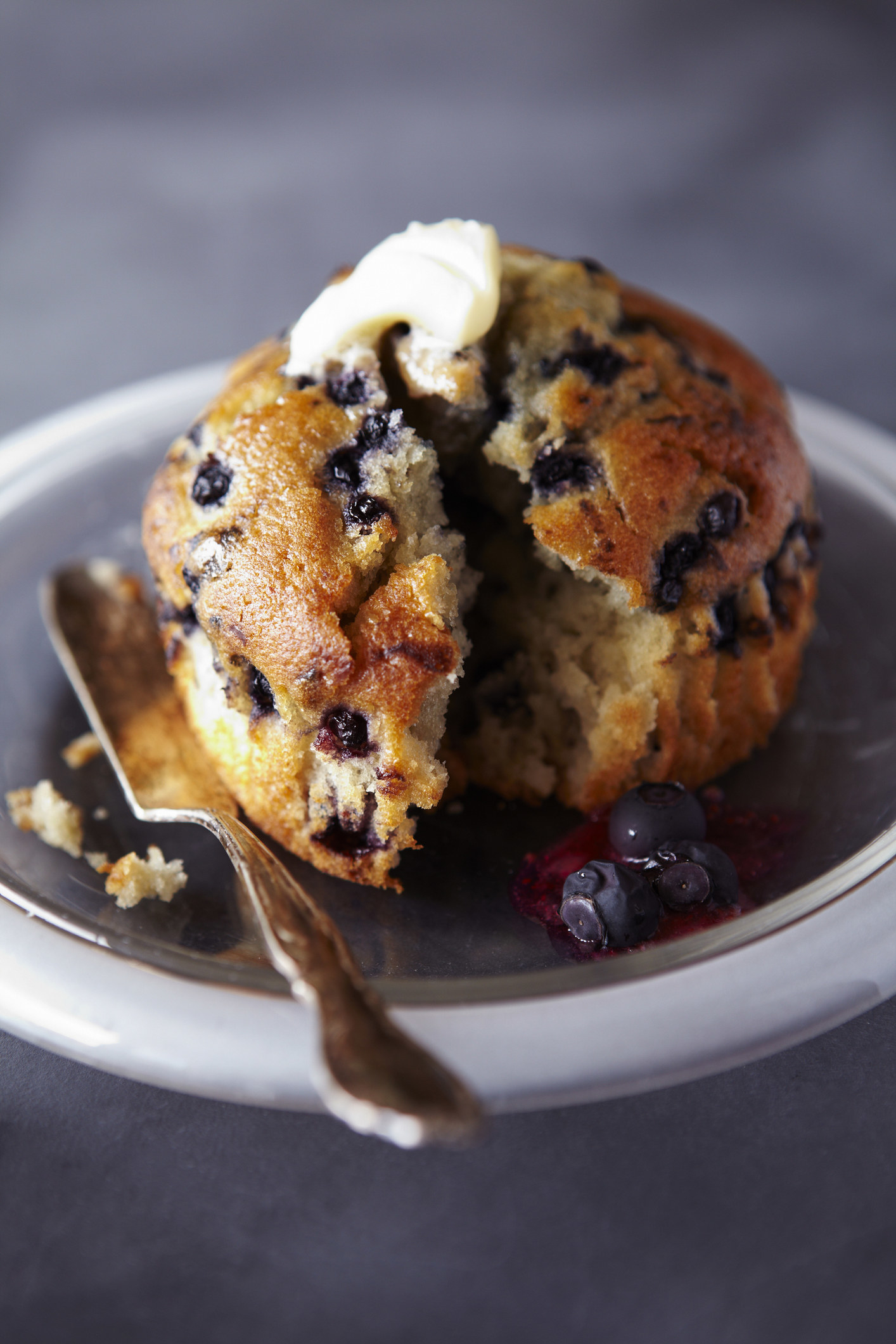 A blueberry muffin with butter.