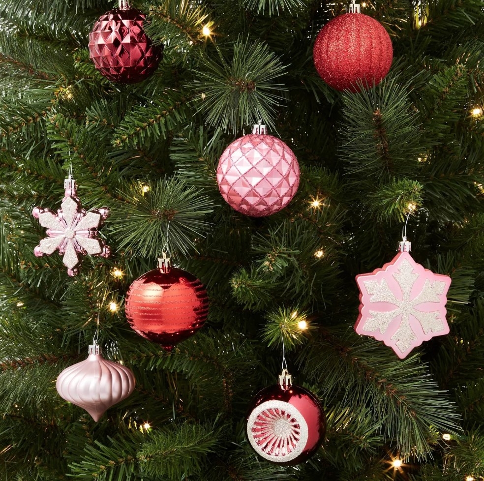Different shaped pink and red ornaments on tree