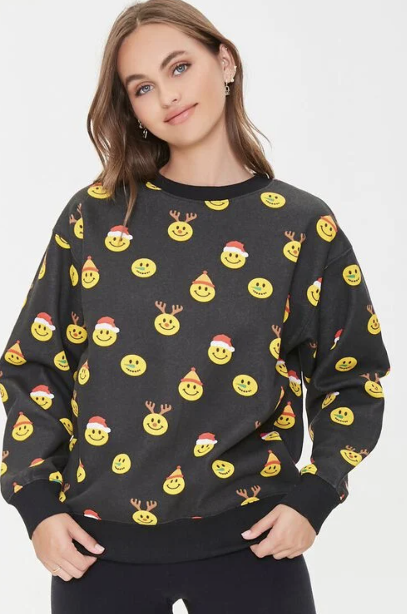 Model wearing Christmas-themed smiley face pullover